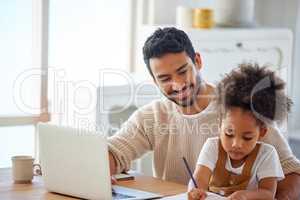 Father helping daughter with homework. Dad working on laptop, daughter drawing a sketch on paper. Man working from home on laptop. Hispanic little girl writing schoolwork on paper