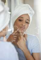 I dont like the look of this. a young woman popping a pimple on her face at home.