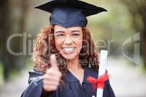 Never stop learning because life never stops teaching. Portrait of a young woman holding her diploma and showing thumbs up on graduation day.