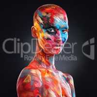 Even my flaws add to my masterpiece. an attractive young woman posing alone in the studio with paint on her face and body.