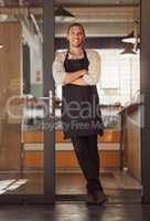 Portrait of proud small business owner in his restaurant. Young mixed race businessman standing in his cafe entrance. Bistro owner arms crossed standing in his supermarket. Boss standing by his door