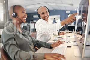 Mixed race male call centre telemarketing agent discussing plans with colleague while working together on computer in an office. Two consultants troubleshooting solution for customer service and sales support