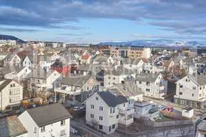 The small city of Bodo in Norway with a cloudy or overcast blue sky. A beautiful scenic view of urban landscape streets and buildings with copy space. Peaceful rural town from above