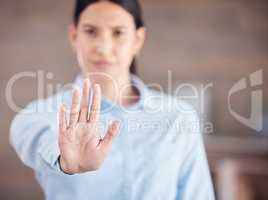 Closeup of of the hand of a mixed race business man gesturing stop while standing in her office. Stop gender based violence and sexual harassment in the workplace. Take a stand. Enough is enough
