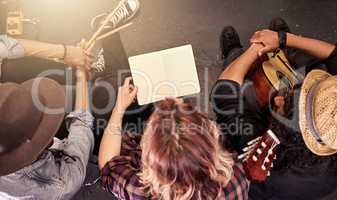 Making sure theyve got the music down. High angle shot of an unrecognizable band reading their sheet music on stage before a gig.