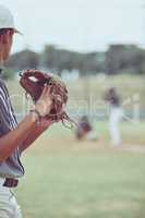 Closeup of a pitcher playing a baseball match. Sports player in action about to throw the ball to a batter. Competitive athlete at a game of baseball in a stadium between two teams