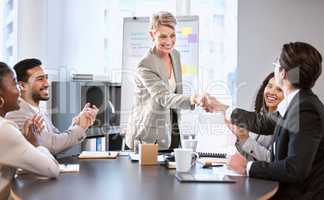 I would like to personally commend you on your performance. a senior businesswoman shaking hands with a colleague during a meeting in an office.