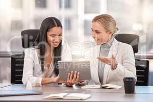 Surround yourself with strong women. Shot of two businesswomen planning together while using a digital tablet.