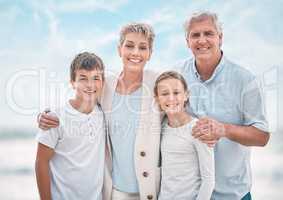 Leave them loved. a mature couple bonding with their grandchildren at the beach.