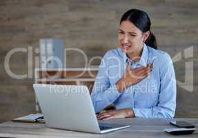 Young hispanic woman suffering from chest pain in office. Mixed race businesswoman feeling unwell while using a laptop at work