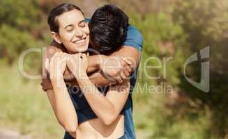 Affectionate young interracial couple taking a break from exercise and run outdoors. Loving man hugging arm around woman while motivating each other towards better health and fitness