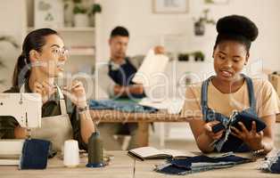 Diverse designers talking about fabric sample. Seamstress colleagues talking about denim material.Two fashion designers talking about textile samples. Creative businesswomen collaborate