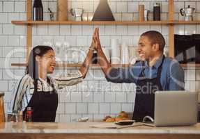 Business partners high five each other. Happy colleagues motivate each other in a shop. Restaurant owners collaborate and celebrate together. Entrepreneurs celebrate their coffeeshop success