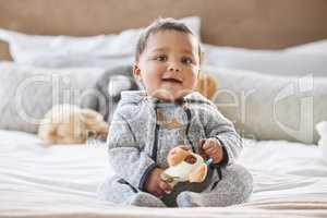 This guys got jokes. Shot of an adorable baby boy playing on the bed at home.
