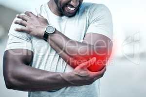 Closeup fit mixed race man holding his elbow in pain while exercising outdoors. Unrecognizable male athlete suffering with a joint injury highlighted by glowing cgi. You can get hurt during a workout