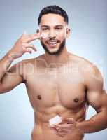 A good skincare routine will never fail you. Shot of a handsome young man applying moisturiser to his face against a studio background.