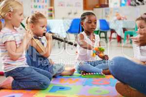 Let them play freely and explore the sounds. children learning about musical instruments in class.