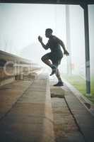 Building speed and endurance. a muscular young man running up steps outdoors.