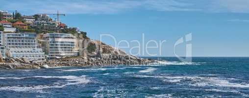 Coastal view of Cape Town and mountain landscape on a sunny day. View of the ocean and city against a blue horizon. A popular travel destination for tourists and hikers, in Lions Head, South Africa