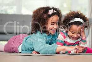 Taking turns to enjoy their favourite digital games. two little girls playing on a digital tablet together at home.