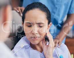 Ready to alleviate some pain. a young woman in pain at her dentists office.