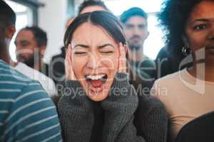 What goods religion when its each other we despise. Shot of a young woman experiencing mental illness while being surrounded by people inside.