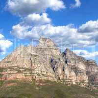 Rocky mountain landscape with green pasture against a blue sky with copyspace. A popular travel destination for tourists and hikers to explore. View of Table Mountain in Cape Town, Western Cape