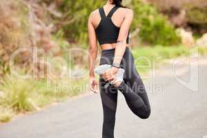 Start your day the right way. Rearview shot of a sporty young woman stretching her legs while exercising outdoors.