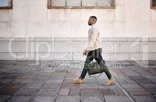 Black businessman travelling alone.A african american businessman walking around town with his luggage while looking stylish in the city