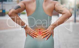 Closeup shot of a young african american woman suffering with back pain while working out in the city. Superimposed cgi highlighting an injury where a female athlete is struggling with lower back ache