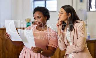 Well pay off this small business loan in no time. two attractive young female business owners looking over paperwork while standing in their store.