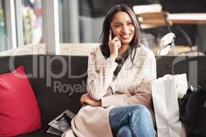 Its been a beautiful day. a young woman taking a break from shopping to make a phone call.