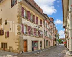 Street view of old buildings in a historic city with built medieval architecture and a cloudy blue sky in Annecy, France. Beautiful landscape of an empty small urban town with homes or houses