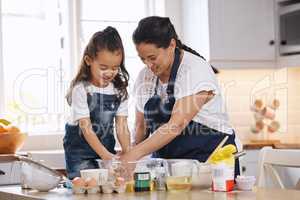 Baking is our favourite mother and daughter activity. Shot of a mother and her young daughter baking together at home.