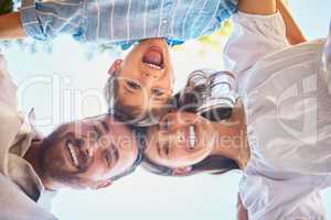 Family of three from below. Portrait of a young couple and their cute son posing outside with the clear blue sky in the background. Happy boy smiling with his mother and father outdoors during summer