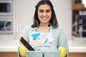 Cleanliness is next to Godliness. a woman holding a basket with cleaning supplies.