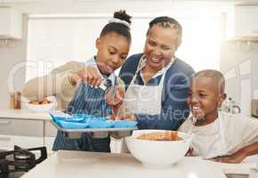 Leave some room. a grandmother baking with her two grandkids at home.