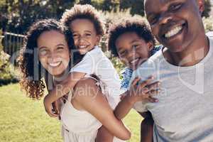 Happy african american family of four having fun and playing together in the sun. Carefree parents carrying sons for piggyback ride while bonding at park. Mom and dad enjoying quality time with kids