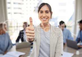 May all your opportunities lead to success. Closeup shot of a young businesswoman showing thumbs up in an office with her colleagues in the background.