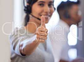 I earned a great commission on this sale. Closeup shot of a call centre agent showing thumbs up while working in an office.