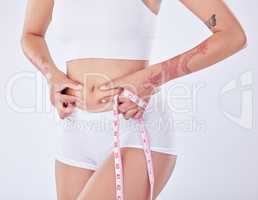 Wheres this come from. Studio shot of an unrecognizable woman measuring her waist against a white background.