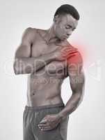 Seek medical help if the pain doesnt subside. Black and white shot of a muscular young man experiencing shoulder pain against a grey background.