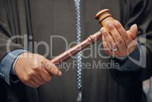 Time to lay down the law. an unrecognizable lawyer holding a gavel at work.