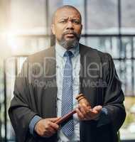 Serious about justice. a mature male lawyer holding a gavel at work.