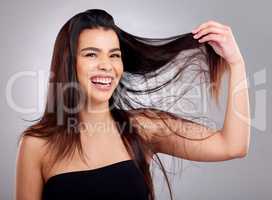 Not a knot in sight. Studio portrait of an attractive young woman posing against a grey background.