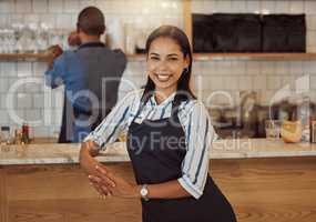 Barista in her cafe kitchen. Business owner working in her coffeeshop with her partner. Colleagues together in their restaurant. Portrait of a boss in her retail store with her partner