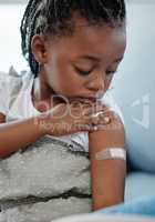 Vaccinate to protect your child against many dangerous diseases. Shot of an adorable little girl with a plaster on her arm after an injection.