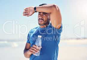 That run was super intense. Shot of a man holding a bottle water while looking exhausted during his run.