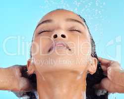 Life is easier when youre comfortable in your own skin. an attractive young woman showering against a blue background.