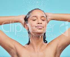 Let the water wash over you. a young woman washing her hair in the shower against a blue background.